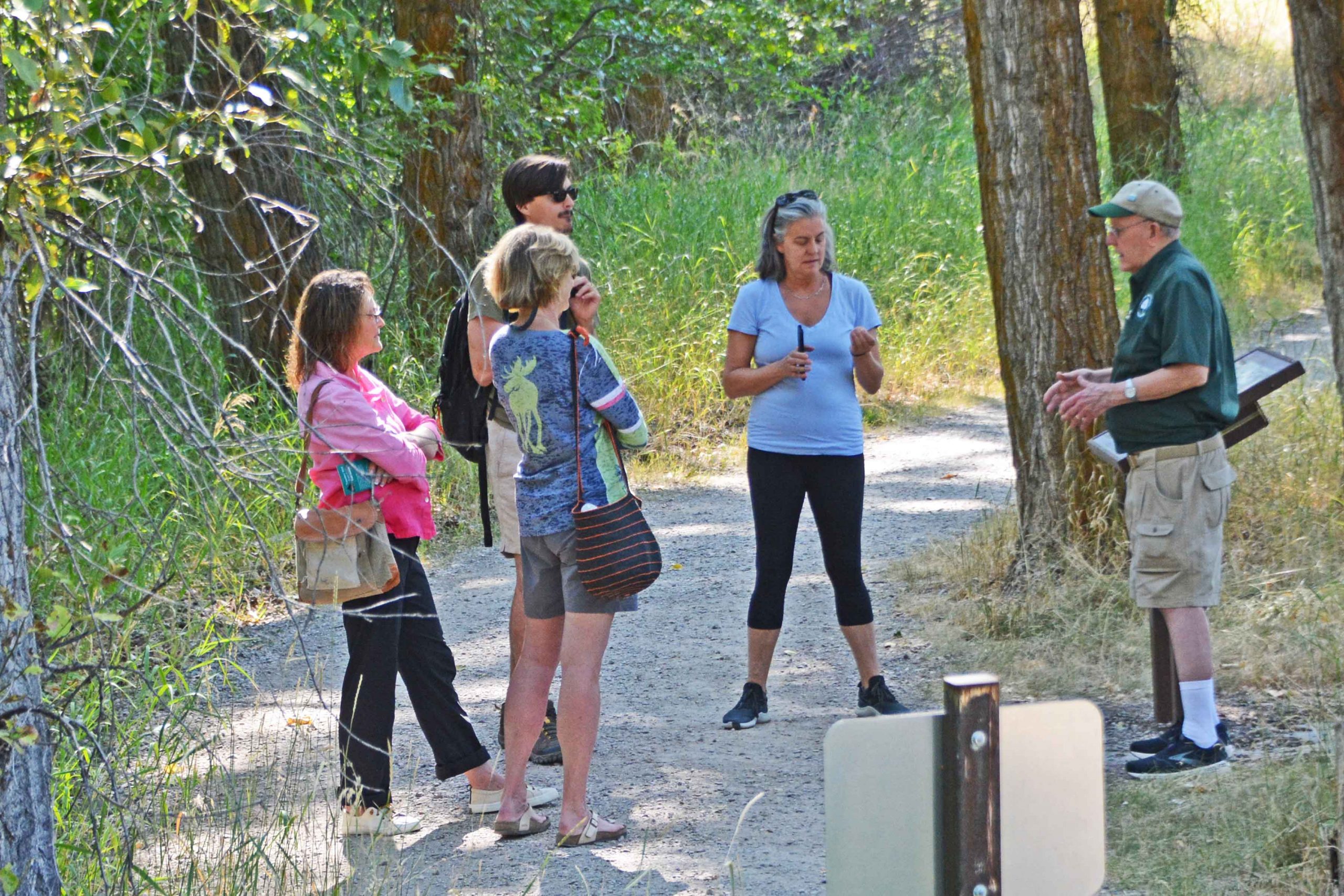 A guide speaks with visitors on a trail at Travelers' Rest State Park.